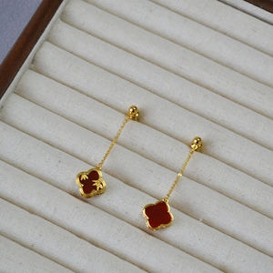Retro bamboo clover earrings with red agate pendants on a velvet jewelry tray