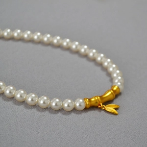 Collier de perles élégant avec pendentif bambou doré et breloque feuille au style rétro