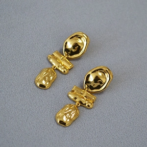 Detail of gold baroque irregular wavy drop earrings with hammered texture finish
