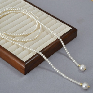 Vue détaillée d'un long collier de perles avec accents dorés et grands pendentifs