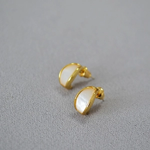 Macro dei perni per orecchi placcati oro con inserto in conchiglia a forma di arco