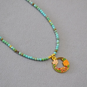 Collier artisanal en perles de turquoise avec pendentif émaillé doré de style ethnique