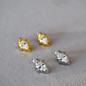Macro shot of lava-textured silver and gold earrings with marquise-cut cubic zirconia
