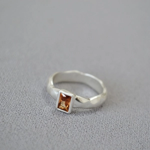 Retro hammered silver ring with rectangle amber zircon crystal on textured fabric