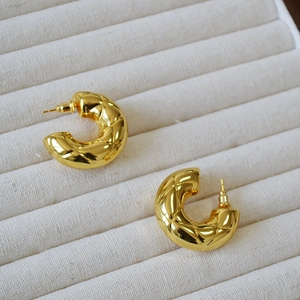 Quilted 18K gold plated hollow brass C-shaped hoop earrings on display tray