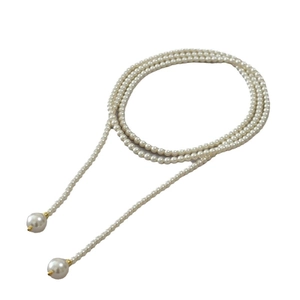 Élégant long collier de perles blanches avec des touches dorées en forme de Y pour pull