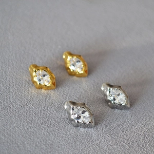 Detailed close-up of irregular lava texture earrings with sparkling zircon stones
