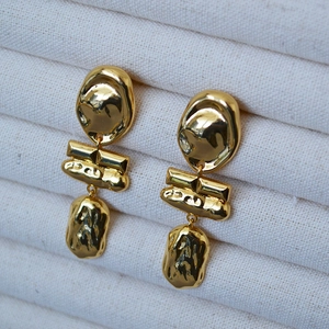 Detail of irregular lava texture on golden brass baroque earrings with 925 silver pins