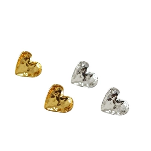 Minimalist curled heart stud earrings in gold and silver with textured hammered metal finish