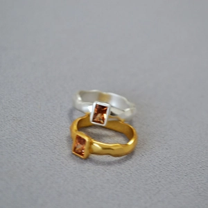 Macro shot of minimalist hammered texture rings with rectangular amber zircon stones