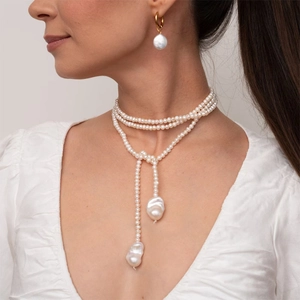 Detail of multilayer pearl necklace and baroque pendants with matching gold hoop earrings