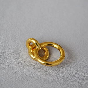Macro shot of minimalist triple interlocking gold rings with a polished mirror finish