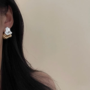 Artistic irregular lava texture earrings in silver and gold contrast worn by model