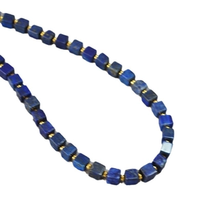Modern lapis lazuli square bead necklace with gold spacers on white background