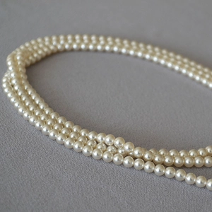 Detailed macro view of a three-layer Baroque pearl necklace with elegant round pearls
