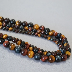 Macro shot of polished 4mm-12mm mixed tiger eye stone beads with silk luster finish