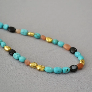 Detailed macro view of baroque turquoise beads with vintage irregular gold metal accents