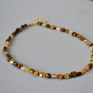 Detail of tiger eye and sunstone beaded necklace with gold metal clasp and chain