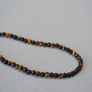 Macro detail of natural tiger eye stone beads in mixed colors for a vintage necklace