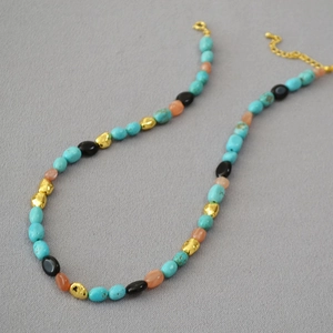 Detail of bohemian turquoise beaded necklace with gold lobster clasp and adjustable chain