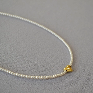 Elegant pearl choker necklace with gold heart pendant and minimalist small white beads