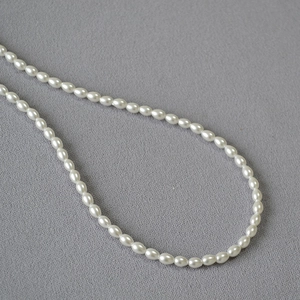 Vue macro de perles de riz blanches élégantes avec un lustre doux sur tissu texturé