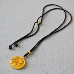 Detailed macro view of Chinese gold hollow disc pendant with colorful bead accents