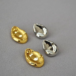 Irregular liquid metal drop earrings in gold and silver finish with minimalist lava texture