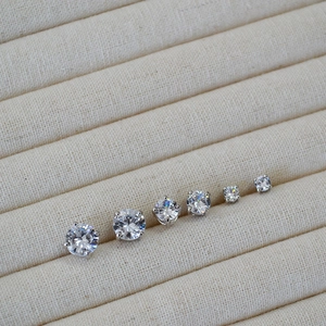 Macro detail of six classic four-prong cubic zirconia stud earrings in a jewelry box