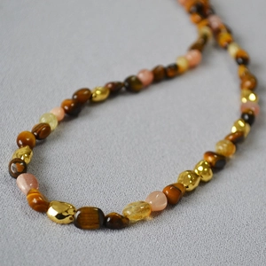 Macro detail of natural tiger eye and moonstone beads on a vintage bohemian necklace