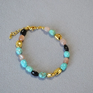 Close-up of bohemian beaded necklace with turquoise, onyx, and golden accent beads