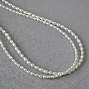 Vue macro d'un élégant collier double rang en perles de riz blanches et brillantes