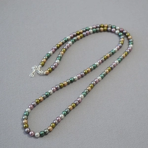 Detail of colorful faux pearl necklace showing mixed pastel beads and silver lobster clasp