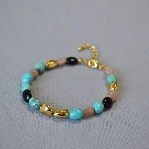 Detailed shot of turquoise and gold beaded necklace with adjustable lobster clasp