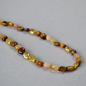 Detailed shot of tiger eye beads and golden hammered spacers on a retro beaded necklace