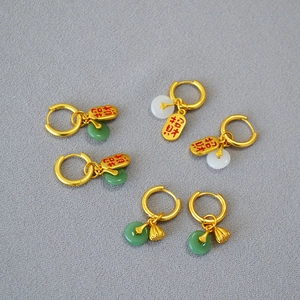 Vue détaillée des boucles d'oreilles bouclier de paix dorées avec accents de jade de style chinois