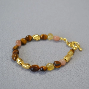 Detail view of tiger eye beads, yellow crystals and golden spacers on a beaded necklace