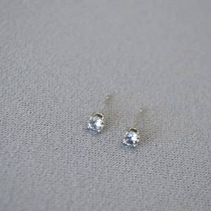 Macro detail of four-prong silver studs with sparkling round-cut cubic zirconia crystals