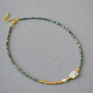 Detail of turquoise beaded necklace featuring a baroque pearl and adjustable lobster clasp