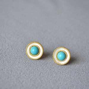 Detail of vintage round stud earrings with turquoise center and white mother of pearl