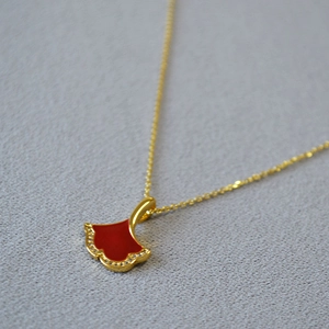 Détail du pendentif feuille de ginkgo avec émail rouge et zircons pavés dorés