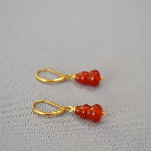 New Chinese style red agate gourd drop earrings with gold hooks on grey fabric background