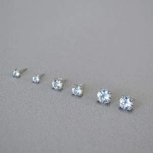 Macro shot of silver stud earrings with sparkling cubic zirconia in four-prong settings