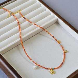 French vintage necklace with red beads, pearl and gold coin pendant on jewelry tray