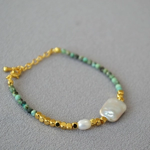 Close-up of Baroque pearl necklace with turquoise beads and gold metallic accents
