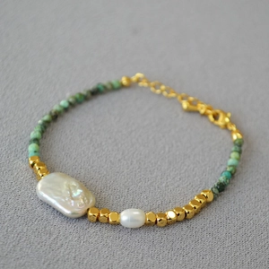Detail of baroque pearl and green turquoise beaded necklace with gold lobster clasp