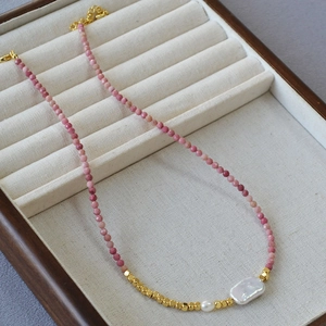 Detail showing baroque pearl and pink faceted stone beads in a wooden jewelry box