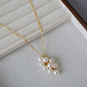 Détail macro du pendentif grappe de perles sur une chaîne fine dorée élégante
