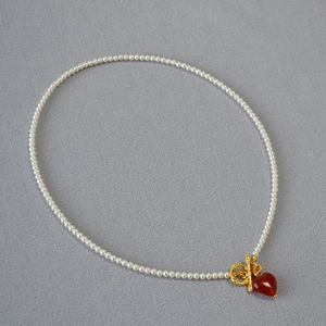Elegant pearl necklace featuring a red heart agate pendant and gold OT toggle clasp