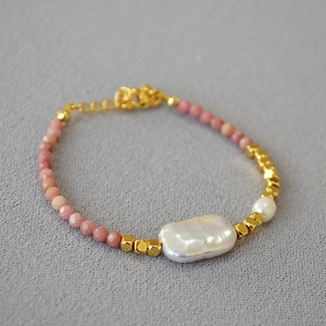 Macro detail of handmade beaded necklace with baroque pearls and pink gemstone beads